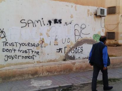Un ciudadano pasa al lado de un graffiti que proclama: 'Confía en ti, no en el Gobierno'.
