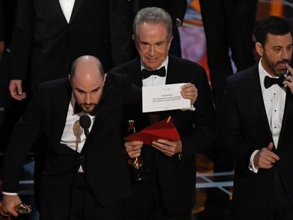 El actor Warren Beatty (centro) muestra el sobre correcto tras rectificar el error.