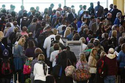 Varios pasajeros fueron registrados este viernes al  esperar en línea en el aeropuerto de Arlington, Virginia (EE.UU.), afectados por los retrasos en cientos de vuelos como consecuencia de las medidas de recorte del gasto que comenzaron a ser aplicadas esta semana.