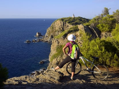 Una ciclista contempla el mar en la isla de Porquerolles, en la  Costa Azul francesa.