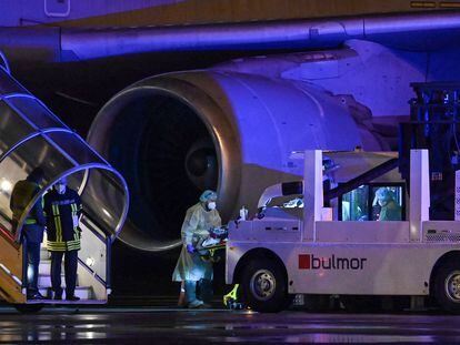 Médicos transportando a enfermos de coronavirus graves en un avión medicalizado.