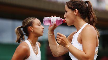 La tenista británica Jodie Burrage (a la derecha) se hidrata durante un partido de dobles con su compañera Eden Silva, en junio, durante el campeonato de Wimbledon.
