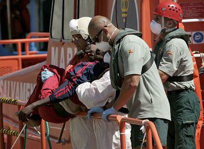 Miembros de Cruz Roja desembarcan a uno de los inmigrantes heridos en el puerto de Arguineguín.