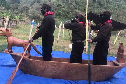 Tres zapatistas abordo de una de las embarcaciones de madera que construyeron.