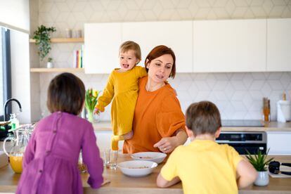 Una madre prepara el desayuno para sus tres hijos.