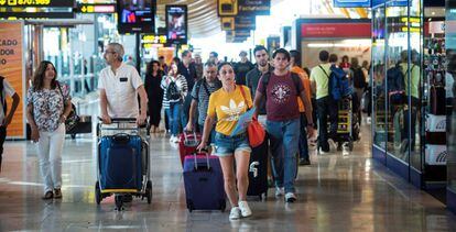 Viajeros transitan por la terminal 4 del aeropuerto de Barajas en Madrid. 