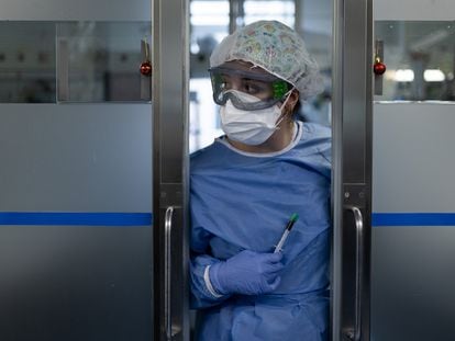Una sanitaria ataviada con el equipo de protección individual aguarda en la puerta del box de un paciente con covid en la Unidad de Vigilancia Intensiva Respiratoria del Hospital Clínic de Barcelona, el día 16.