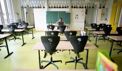 Una profesora da clases por ordenador desde un aula vacía en Alemania.