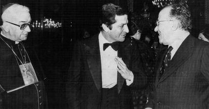 El presidente del Gobierno, Adolfo Suárez, (centro) conversa con el secretario general del Partido Comunista, Santiago Carrillo, y el arzobispo de Madrid, Enrique Vicente y Tarancón, en una cela de gala en el Palacio Real el 14 de marzo de 1978.
