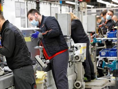 Varios operarios de SEAT trabajan en la cadena de montaje. 