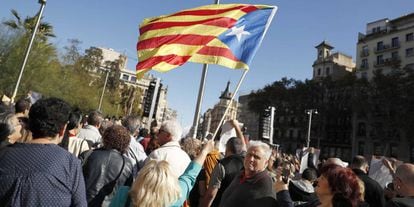 Una mujer sostiene una estelada, en una pegada de carteles en Barcelona. 