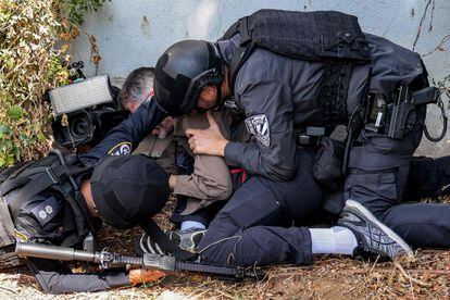 Policías israelíes ayudan a un periodista a cubrirse durante una alerta por un ataque con cohetes en la ciudad de Sderot, en el sur de Israel, este jueves. 