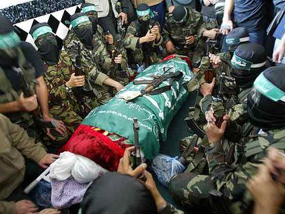 Milicianos de Hamás rodean el cadáver del juez Bassam al Fara durante su funeral, ayer en Jan Yunis.