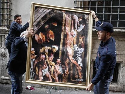 Dos policías retiran la obra del artista urbano 'El incendio del Nazareno', que parodia una pieza de Sanzio con Berlusconi y Renzi. 