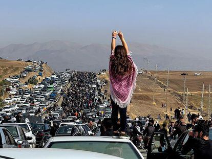 Una joven sin velo sobre el techo de un coche frente a la multitud que este miércoles se dirigía al cementerio de Aichi, en Saqqez, donde está enterrada Mahsa Amini.