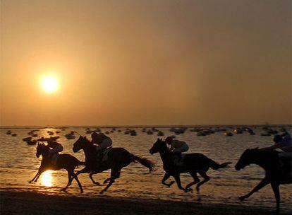 Tercera carrera de caballos anoche en la playa de Sanlúcar de Barrameda.