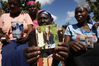 La abuela de uno de los 33 niños (centro), rodeada de otras madres, muestra la foto de su nieta con Laura Silsby, líder de los baptistas.