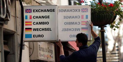 Un trabajador coloca un cartel de cambio de moneda en Gibraltar.