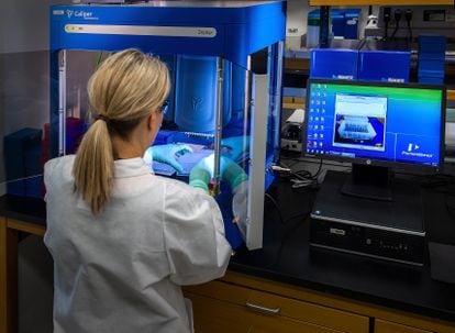 Una científica del CDC estadounidense trabaja junto a una estación de biología molecular.