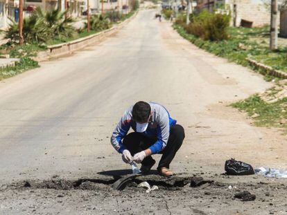 Un sirio recoge muestras de supuestos componentes químicos tras el ataque del martes.
