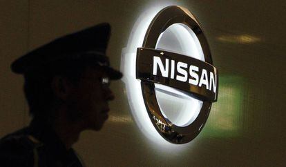 Un guardia de seguridad, frente a un logo de Nissan en Tokyo. 