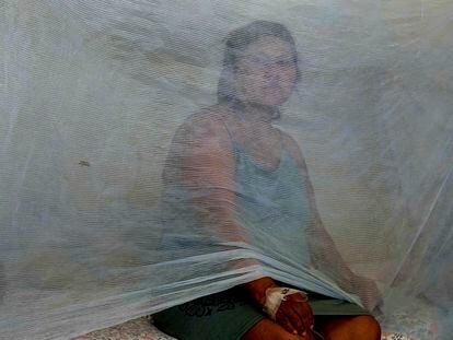 Jenny Chiroque espera sentada en una cama en el hospital de La Merced para ser atendida por infección de dengue en Perú, en febrero de 2024.