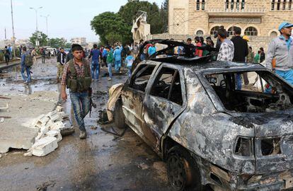 Un grupo de sirios se reúne cerca del vehículo carbonizado tras la explosión. El atentado se produjo cerca de una mezquita y de la sede del gobierno provisional, formado en noviembre de 2013, y que ejerce de administrador en los territorios rebeldes que escapan al control del régimen.