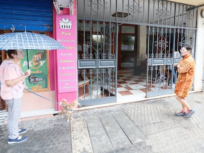 Vecinos de Sevilla caminan frente al portal de la vivienda donde han ocurrido los hechos. EFE/ JOSÉ MANUEL VIDA