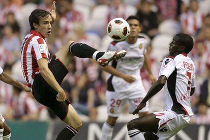 El delantero del Athletic de Bilbao David López lucha por el balón con el francés Michael Pereira.