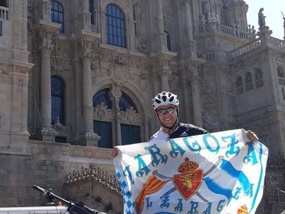 Miguel Cardiel con la bandera del Zaragoza frente a la catedral de Santiago de Compostela tras completar un tramo del Camino de Santiago.