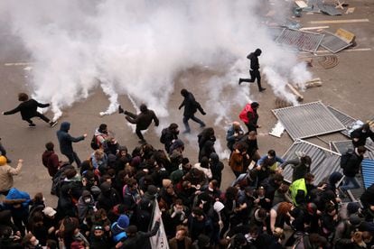 Manifestantes arrojan botes de gas lacrimógeno en medio de enfrentamientos con la policía, este jueves en París.