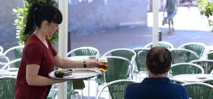 Una camarera sirve una consumici&oacute;n esta ma&ntilde;ana en una terraza de Valladolid.