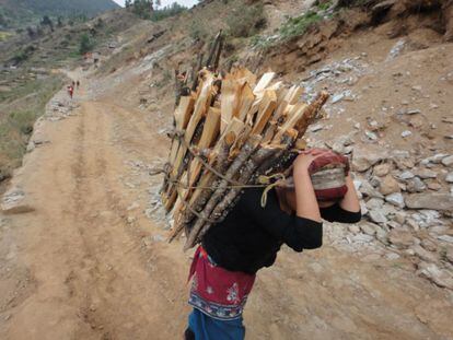 Una mujer transporta madera en el montañoso distrito de Mugu. Aunque las mujeres son conscientes de que no deben llevar cargas pesadas durante el embarazo o después de dar a luz, a menudo no tienen otra opción, por su situación económica o la presión de sus familias. Al llevar cargas pesadas, la musculatura pélvica puede resentirse, aumentando el riesgo de prolapso uterino. En Nepal este problema afecta a 600.000 mujeres muchas de las cuales son menores a 30 años.