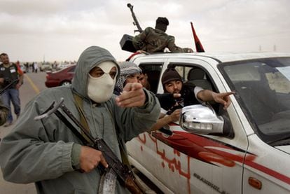 Un grupo de rebeldes libios señala una columna de humo, que no se ve en la foto, cerca de Brega.