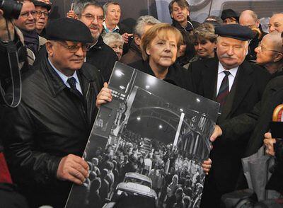 Gorbachov, Merkel y Walesa, con una imagen de la antigua frontera berlinesa tras la caída del Muro.