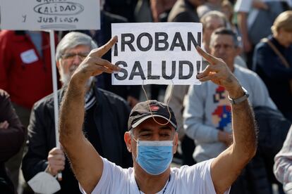 Un manifestante con mascarilla participa en la marcha ciudadana que recorre este domingo el centro de Madrid.