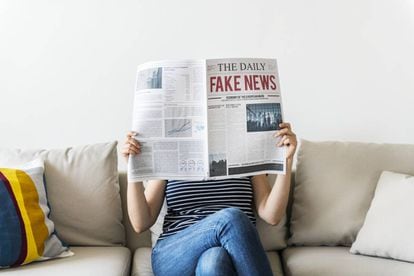 Una mujer leyendo un periódico.