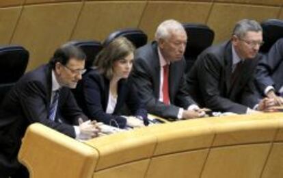 El Presidente del Gobierno, Mariano Rajoy; la vicepresidenta, Soraya Sáenz de Santamaría; el ministro de Asuntos Exterriores, Exteriores, José Manuel Margallo, y el ministro de Justicia, Alberto Ruiz Gallardón (de izq., a dcha.), aparecen en sus respectivos escaños momentos antes del comienzo del pleno del Congreso de los Diputados para la comparecencia del presidente del Gobierno, Mariano Rajoy, sobre el caso Bárcenas y sobre la situación política y económica. EFE/J.J. Guillén