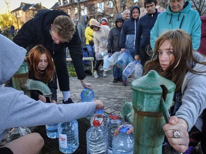 Varias personas llenan garrafas de agua en un parque de Kiev.