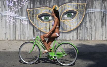 Una chica montando en bicicleta en el Ocean Front Walk de Venice Beach, en Los Ángeles (EE UU).