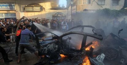 Varios hombres tratan de apagar el fuego del vehículo de Yabari.