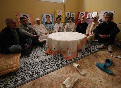 Las familias de Salam Mohand y Rachid Chaib, en la casa del primero, rodeadas de fotografías de los fallecidos.