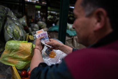 Un vendedor saca su cuenta en el mercado Paloquemao, en Bogotá.