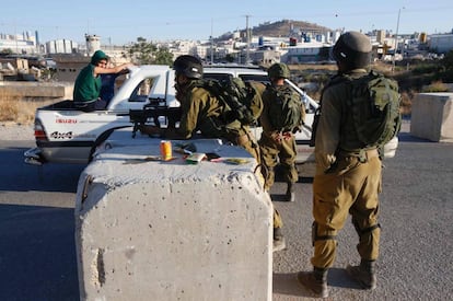 Soldados israelíes registran un coche en un control entre Hebrón y la aldea de Yatta.