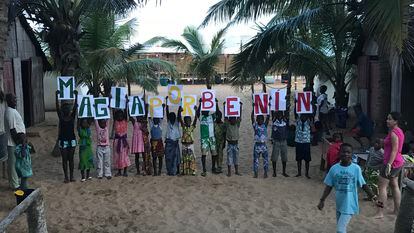 Los niños del centro de Mensajeros por la Paz, posan con un cartel de ‘Magia por Benín’, en Cotonou (Benín).