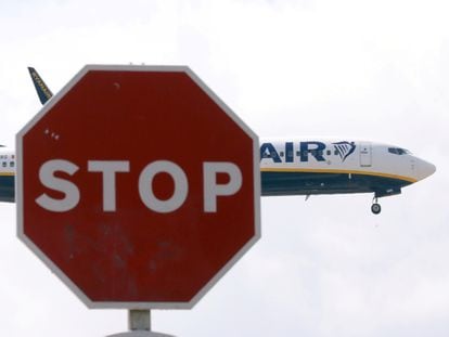 Un avión de Ryanair pasa ante un signo de tráfico durante su aterrizaje en el aeropuerto de El Prat, en Barcelona, en julio de 2018.