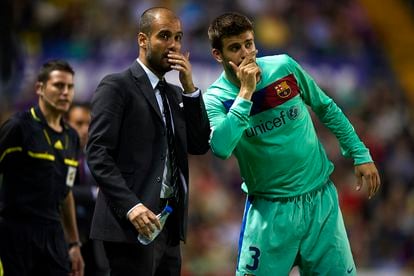 El entrenador del Barça, Josep Guardiola (a la izquierda), da instrucciones a Piqué durante un partido de la Liga, en 2011.