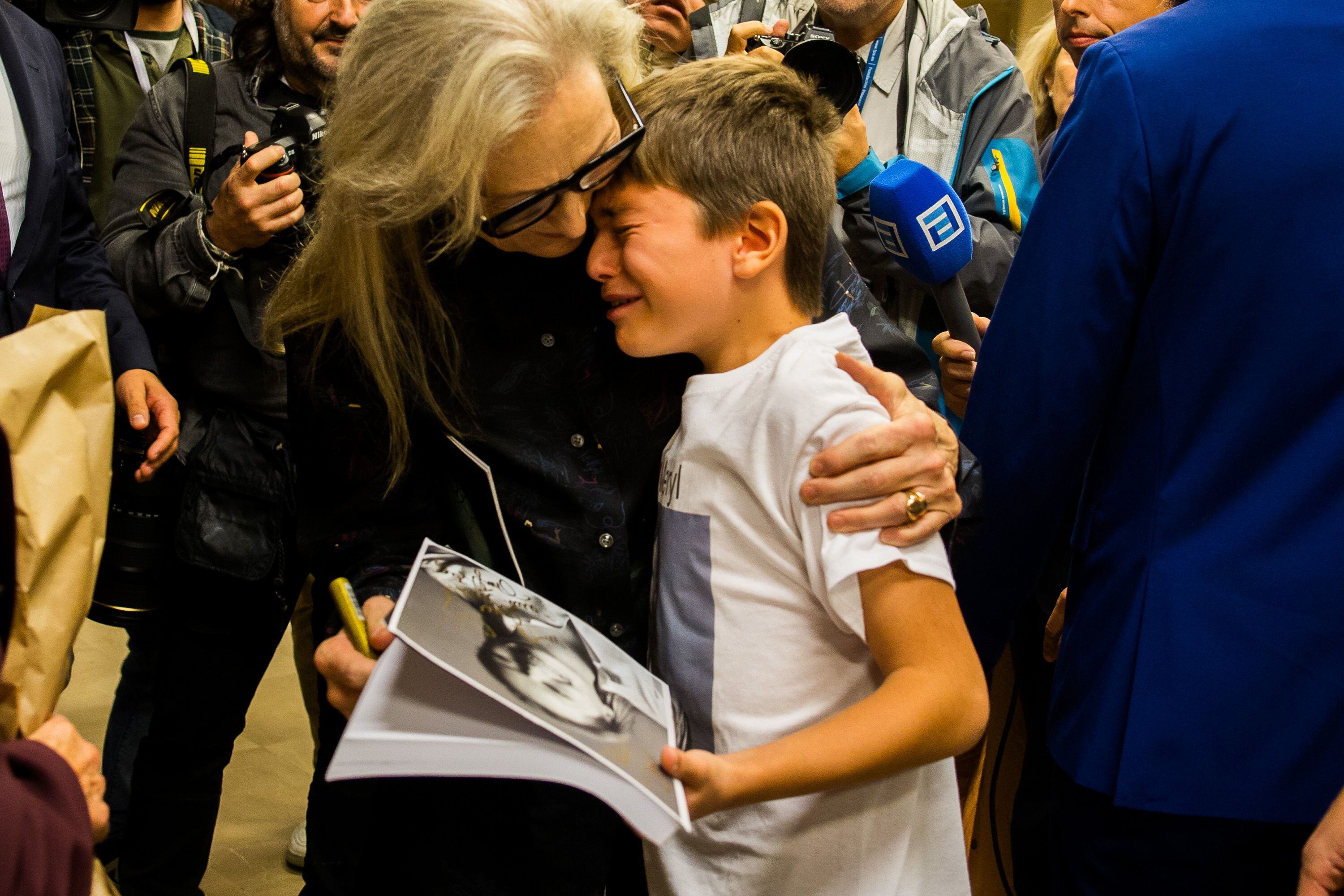 Meryl Streep abraza a un niño durante su visita a la Escuela de Arte Dramático de Gijón, este jueves.