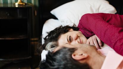 Una pareja tumbada en la cama, posiblemente compartiendo intimidades.