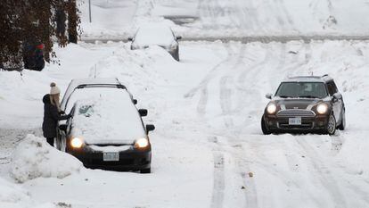 Un automóvil se encuentra atascado en una carretera en el vecindario Sandy Hill de Ottawa. Se espera que la tormenta invernal Elliot también provoque fuertes nevadas y vientos en Canadá.